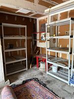 Two white plastic shelving units arranged against a garage wall, showing overall size and condition.