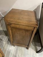 Side view showing wood grain and unfinished side panel with wear consistent with light use