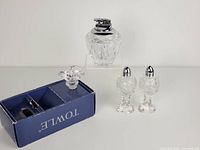 Photo showing vintage crystal salt and pepper shakers with silver-tone tops alongside the crystal table top lighter marked Japan, placed against a plain background.