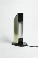 Front view of the lamp showing ribbed gold chrome finish, translucent light panel, and base with cord.