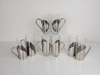 Lot of 8 assorted Danish vintage glass cups with silver steel wrap holders, arranged in sets of twos showing various holder styles and glass heights.