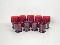 Photo shows full set of 9 ruby red depression glasses: 4 short and 5 tall glasses, all with faceted bases and smooth tops.