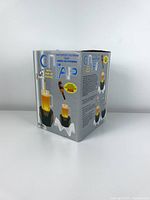 Photo of original box with colorful graphics and text describing the optical illusion drink tap from the 1980s.