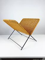 Side angle showing the rattan panels and black metal foldable frame.