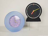 Purple plastic desk/wall clock with translucent light purple frame and gold-tone numbers in face.