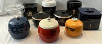 View of 10 vintage plastic ice buckets with liquor brand logos in various shapes and colors.