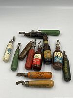 Overview of 12 vintage brewery advertising bottle openers arranged on white background