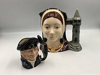 Two Royal Doulton character mugs side by side: Catherine of Aragon and Lobster Man (smaller). Used for size comparison and detailing.