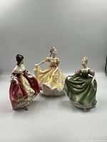 Three Royal Doulton figurines displayed together showing all three characters in color and detail.