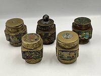 Five brass and cloisonné enamel tea caddies displayed with lids on, showing intricate colorful enamel panels and detailed brass rims.
