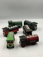 Overview of all six Corgi diecast model beer delivery trucks arranged on white background, showing the various colors and brands.