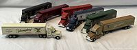 Group shot of all 7 Yuengling beer collectible transport trucks in various colors with advertising graphics visible on the trailers.