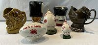 Seven vintage Scotch whisky advertising bar pitchers/decantors showing different character and object shapes.