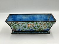 Side view of the rectangular planter showing pale turquoise cloisonné enamel with floral detailing and bronze metal trim.