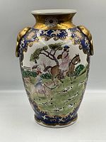 Front view of the antique Chinese Export porcelain vase with painted hunting scene showing horsemen, hounds, and decorative gold-blue border, with sculpted ram head handles.