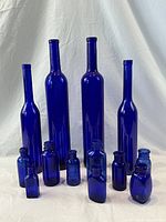 All cobalt blue glass bottles without size reference, showing shape and height variations.