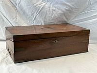 Closed wood box with brass corner plates and side handle
