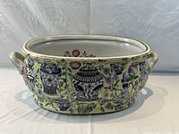 Front view of oval porcelain foot bath tub showing handles and exterior floral and vase motifs