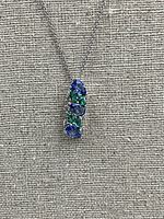 Pendant hanging against beige fabric background showing stone arrangement