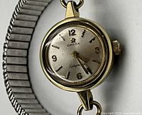 Close-up of watch face showing Omega logo, 'Ladymatic' script, Arabic numerals and hands