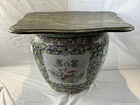 Full view of the large fishbowl planter with green marble top table, showing the shape and proportions.