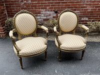Front view of both chairs against brick background.