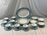 Full lot arranged, showing platter at back, plates, bowls, cups and saucers in front