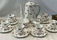 Full set of coffee pot, creamer, sugar bowl, six cups and six saucers arranged