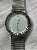 Front view of Skagen Leonora watch showing silver dial with crystal hour markers, Arabic numerals at 3,9,12, and date at 6