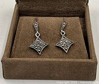 Pair of sterling silver and marcasite square drop dangle stud earrings displayed in a brown jewelry box.