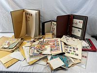 Wide shot of three stamp albums and assorted loose stamps on table