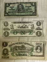 Front side of three one-dollar banknotes from Canada and New England banks, showing detailed engravings, portraits, and text.