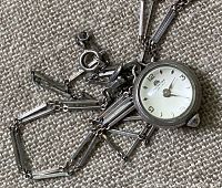 Watch and chain laid out on fabric, showing overall appearance