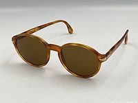 Front view of sunglasses showing round amber frames and brown lenses