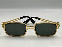 Front view of gold-tone Versace sunglasses with rectangular green lenses and black temple tips