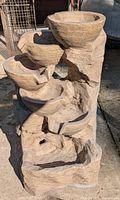 Top and side view of fibreglass 5 tier fountain showing bowls and textured stone-like design with damage on edges of tiers.