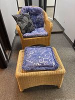 Wicker chair with the matching ottoman and both cushions on a carpeted floor near a mirrored wall.