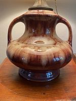 Close-up of ceramic base showing drip glaze and handles