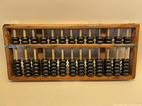 Full view of abacus showing wooden frame, beads, brass corners