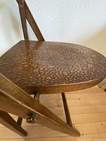 Close view of seat showing raised pebble texture and wooden frame