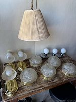 Overall view of all light fixtures showing the group of wall sconces, flush-mount lights, vanity fixture, and hanging pendant.