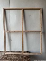 Front view of the extra-large wooden canvas stretcher frame against a neutral wall showing the cross braces and overall rectangular shape.