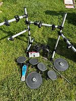Full kit layout on grass showing rack pieces, drum and cymbal pads, module, pedal and cables