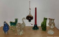 Lot overview showing all eight blown glass items including bird figurines, hummingbird feeder, candle holder, and assorted animals.
