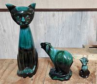 Three Blue Mountain Pottery animal figurines on wooden surface, two cats and one bear