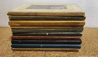Stack of 10 vintage opera books showing varied bindings and colors, illustrating age and condition