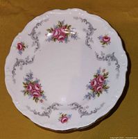 Single Royal Albert dessert plate showing floral pattern with pink roses, gray scrollwork, and gold rim.