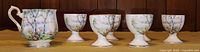 Seven-piece china set including six egg cups and one small handled cup in Royal Albert Silver Birch pattern.
