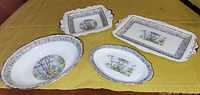 Four Royal Albert Silver Birch pattern china serving dishes displayed on a yellow cloth showing variation in shapes and sizes with birch tree and floral scenic designs in centers and birch bark inspired rims.