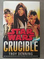 Front cover of the Star Wars Crucible book showing characters Han Solo, Luke Skywalker, and Leia Organa.